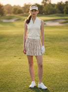 Woman in golf attire standing on a golf course